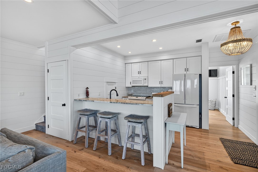 520 Useppa Island Bokeelia, FL 33922 - Photo 16 of 47 a kitchen with stainless steel appliances a dining table chairs and wooden floor