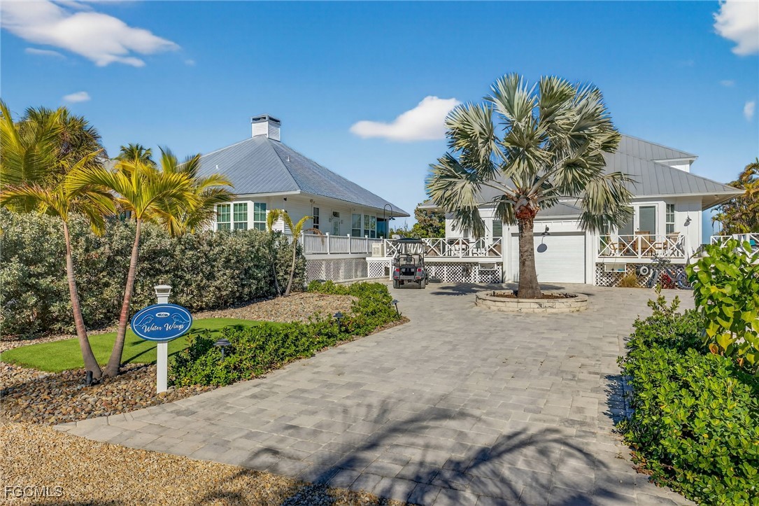 520 Useppa Island Bokeelia, FL 33922 - Photo 5 of 47 a view of a white house with a yard and potted plants