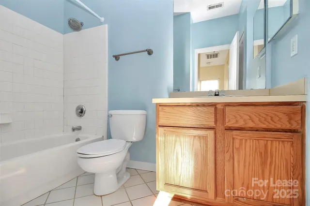 a bathroom with a granite countertop toilet sink and mirror