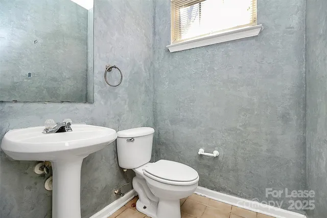 a bathroom with a sink mirror toilet and next to a window