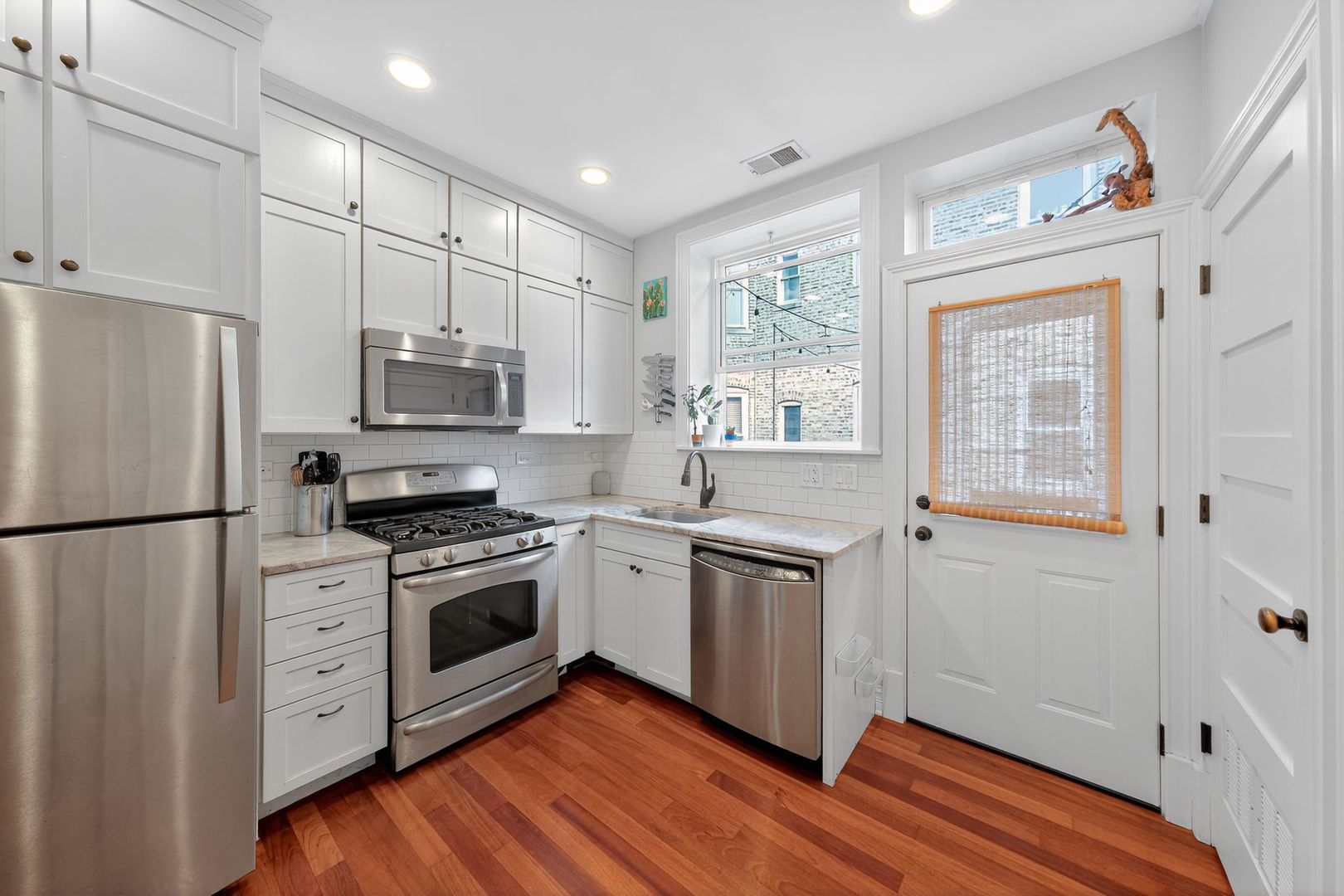2578 West Lyndale Street, Unit 2 Chicago, IL 60647 - Photo 8 of 17 a kitchen with stainless steel appliances a refrigerator a stove a sink and white cabinets