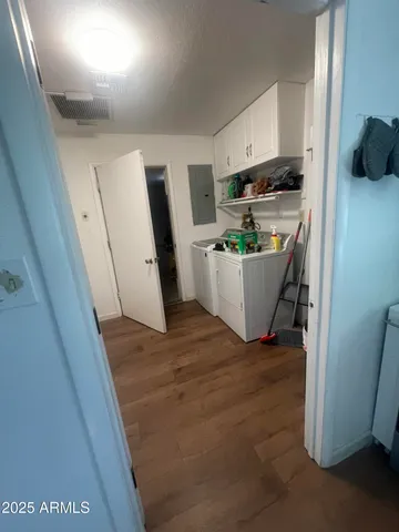a view of a kitchen with fridge and wooden floor