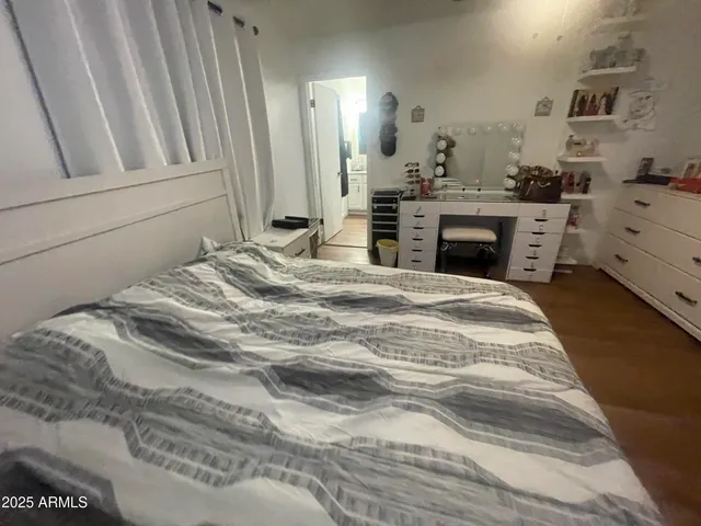 a spacious bedroom with a bed and a dresser