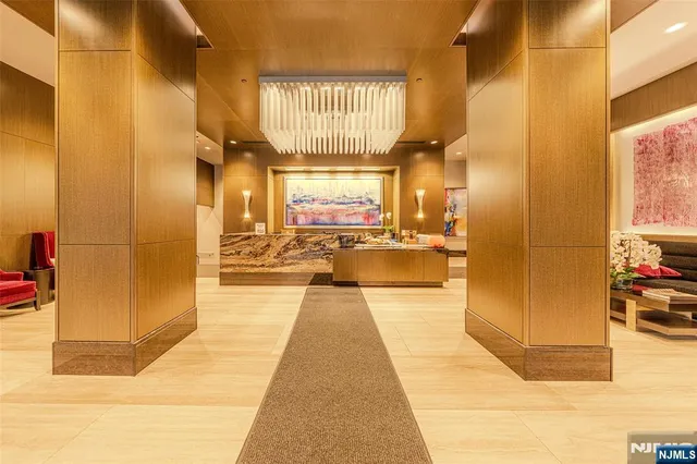 a view of a hallway with wooden floor and a bathroom