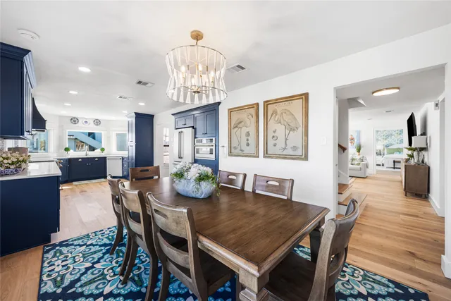 a view of a dining room with furniture a chandelier and wooden floor
