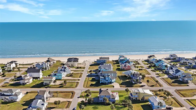 an aerial view of a house with a garden and lake view