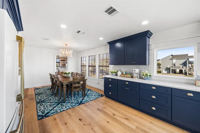 a kitchen with granite countertop dining table chairs cabinets and stainless steel appliances