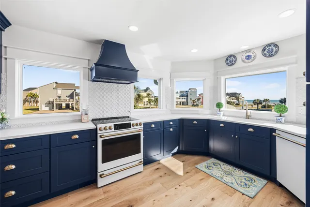 a kitchen with stainless steel appliances granite countertop a stove a sink and a microwave