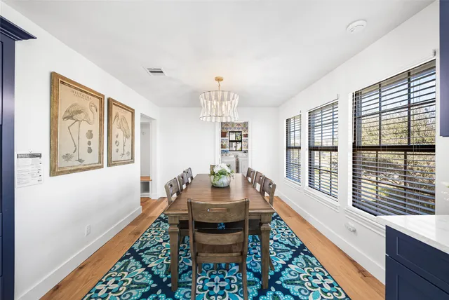 a dining room with furniture a chandelier and wooden floor