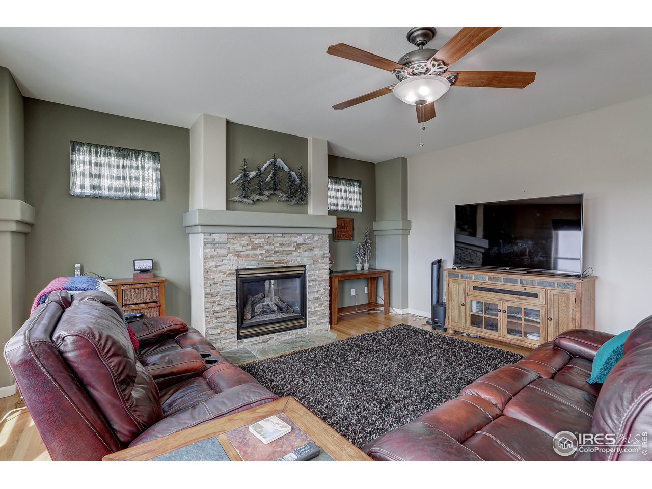 709 Glenarbor Circle Longmont, CO 80504 - Photo 15 of 40 a living room with furniture a flat screen tv and a fireplace