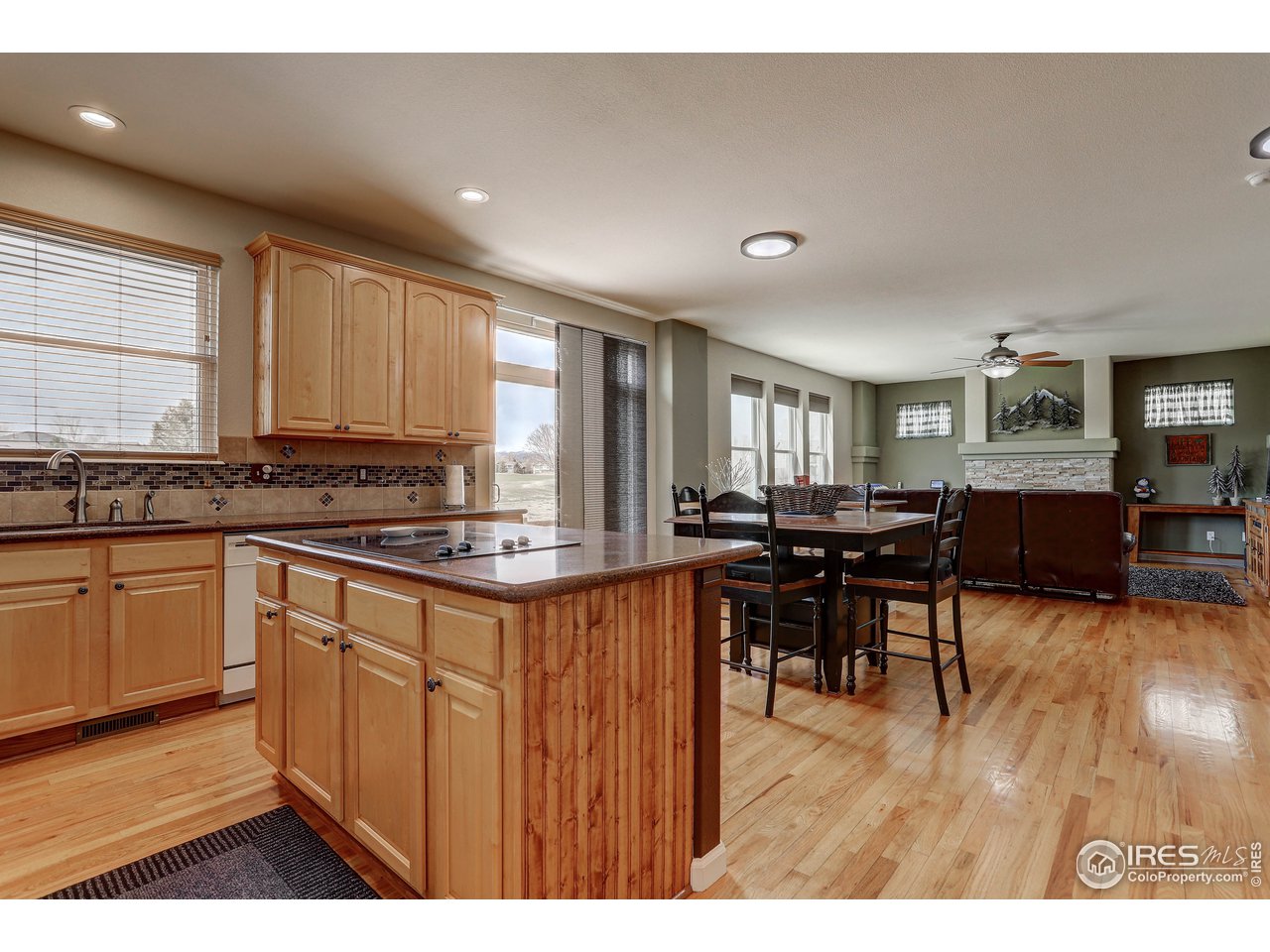 709 Glenarbor Circle Longmont, CO 80504 - Photo 18 of 40 a kitchen with stainless steel appliances granite countertop wooden cabinets a stove a sink a dining table and chairs