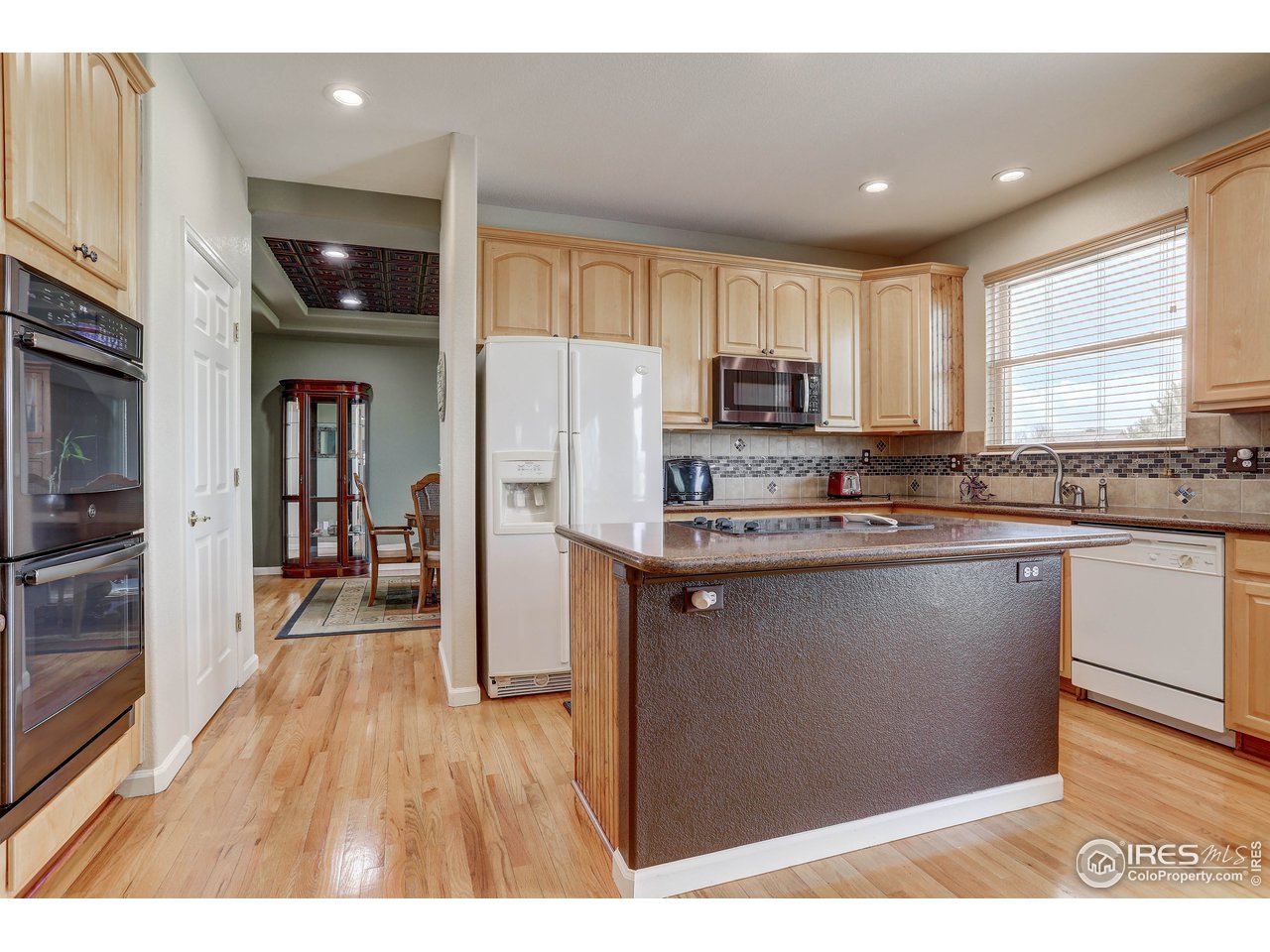 709 Glenarbor Circle Longmont, CO 80504 - Photo 20 of 40 a kitchen with granite countertop a refrigerator and a stove top oven