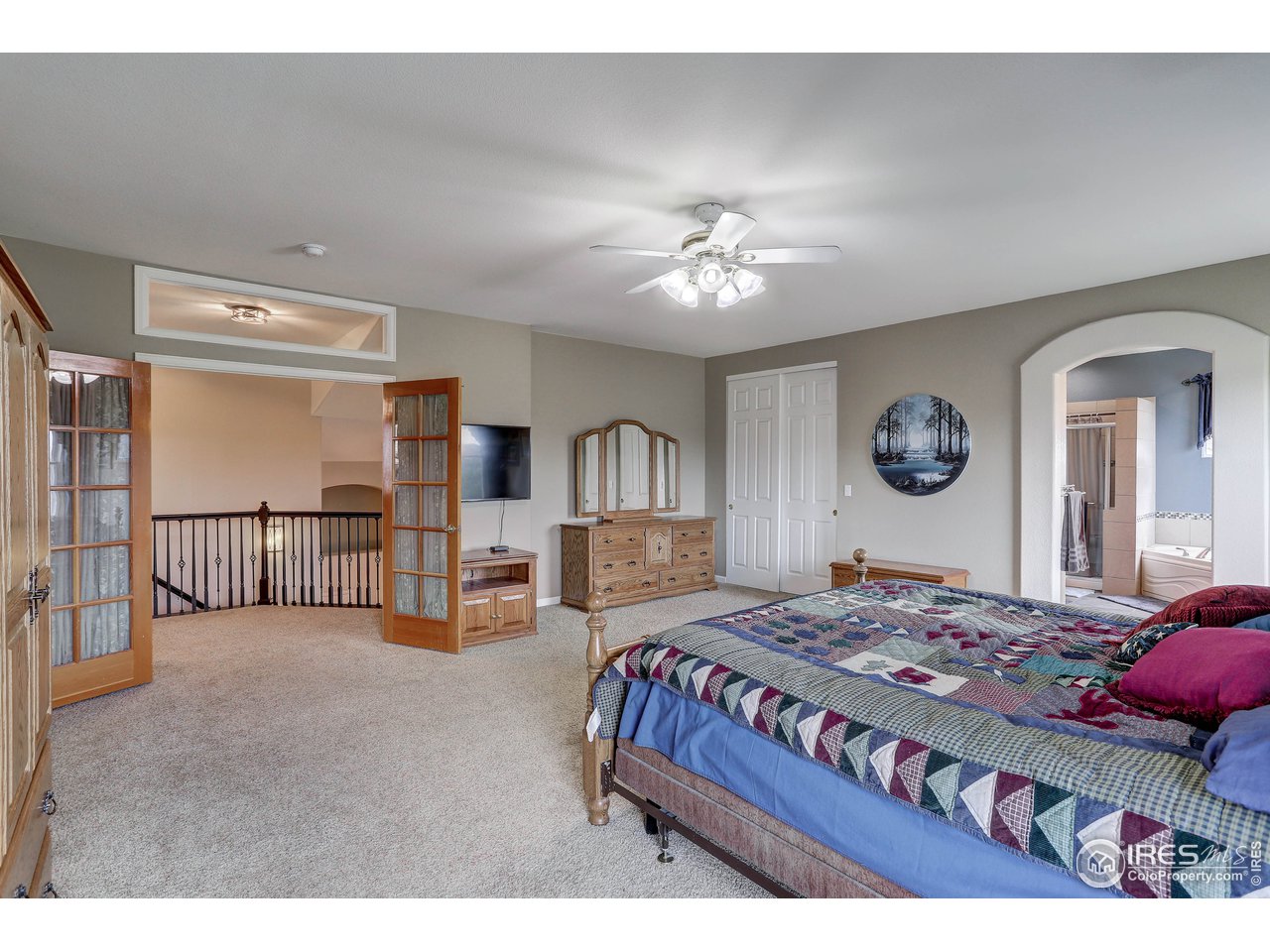 709 Glenarbor Circle Longmont, CO 80504 - Photo 22 of 40 a bedroom with a large bed and a chandelier