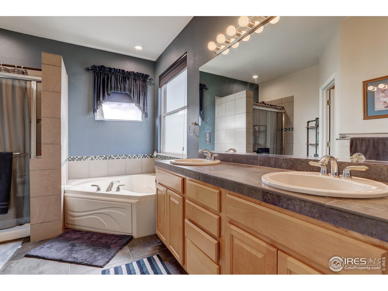 709 Glenarbor Circle Longmont, CO 80504 - Photo 24 of 40 a bathroom with a tub a sink and a mirror