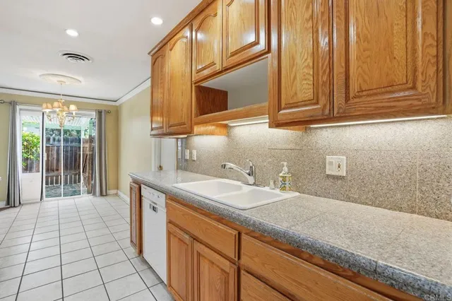 a kitchen with stainless steel appliances granite countertop a sink and dishwasher cabinets with a flat tv screen next to a window