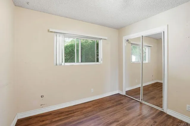 an empty room with wooden floor and window