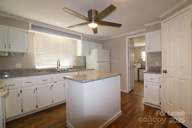 a kitchen with granite countertop a sink a counter space and stainless steel appliances