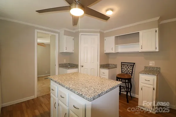 a kitchen with a sink cabinets and wooden floor