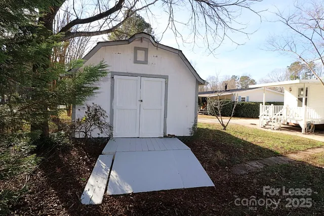 a white house that has tree in front of it