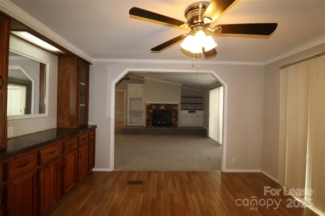 a view of a hallway with wooden floor and a ceiling fan