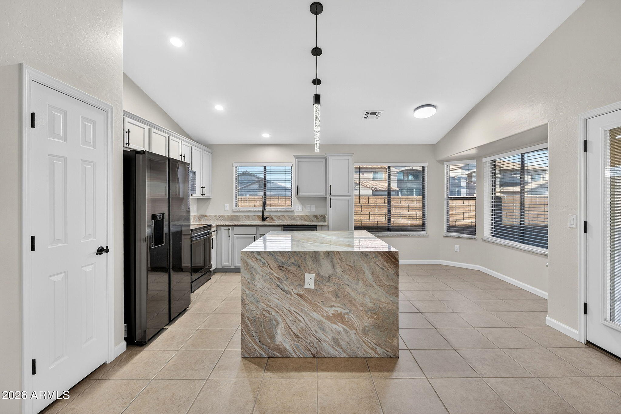 1815 South 174th Avenue Goodyear, AZ 85338 - Photo 11 of 57 a large kitchen with stainless steel appliances kitchen island granite countertop a refrigerator and a stove top oven