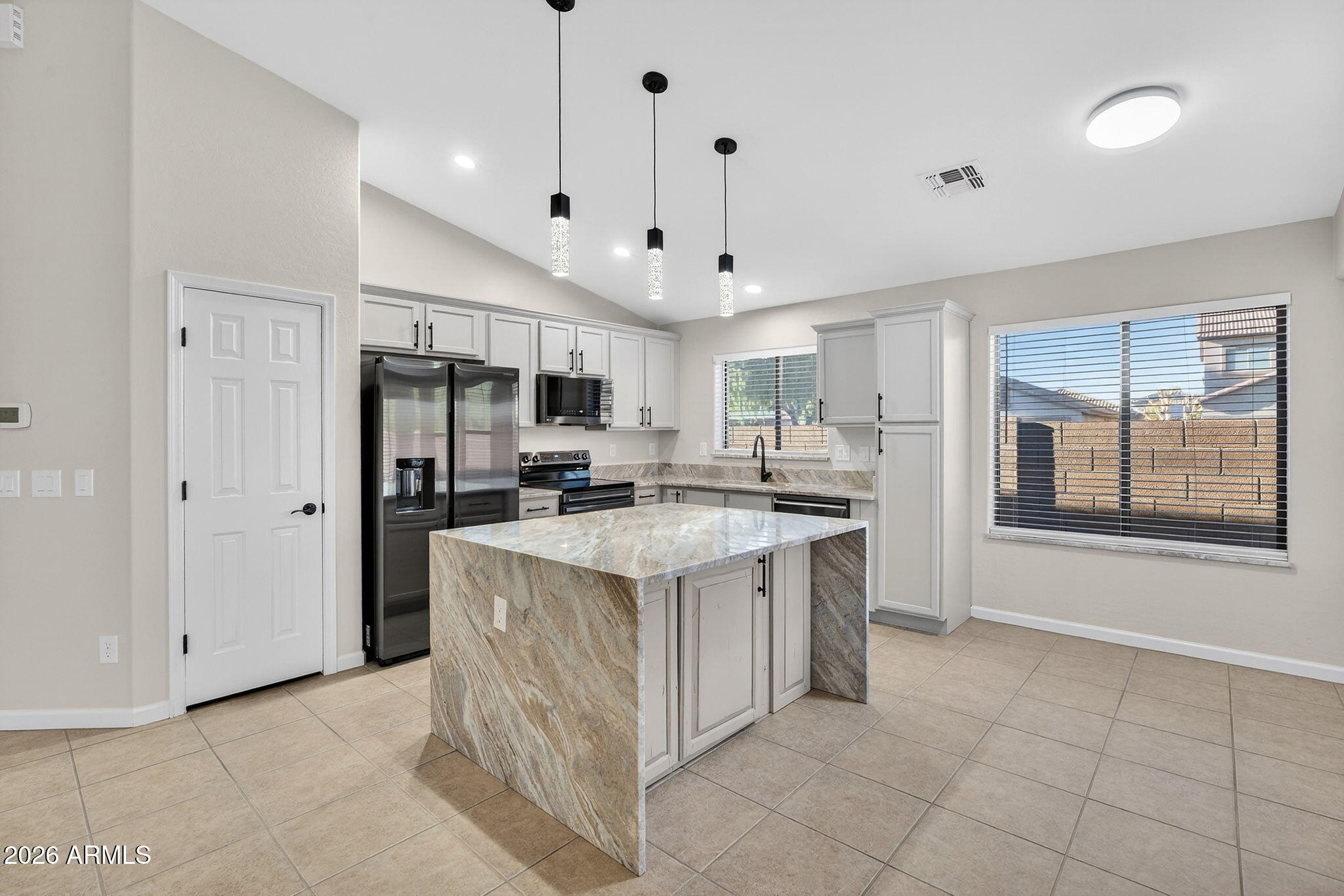 1815 South 174th Avenue Goodyear, AZ 85338 - Photo 13 of 57 a kitchen with stainless steel appliances granite countertop a refrigerator oven a sink dishwasher and white cabinets with wooden floor