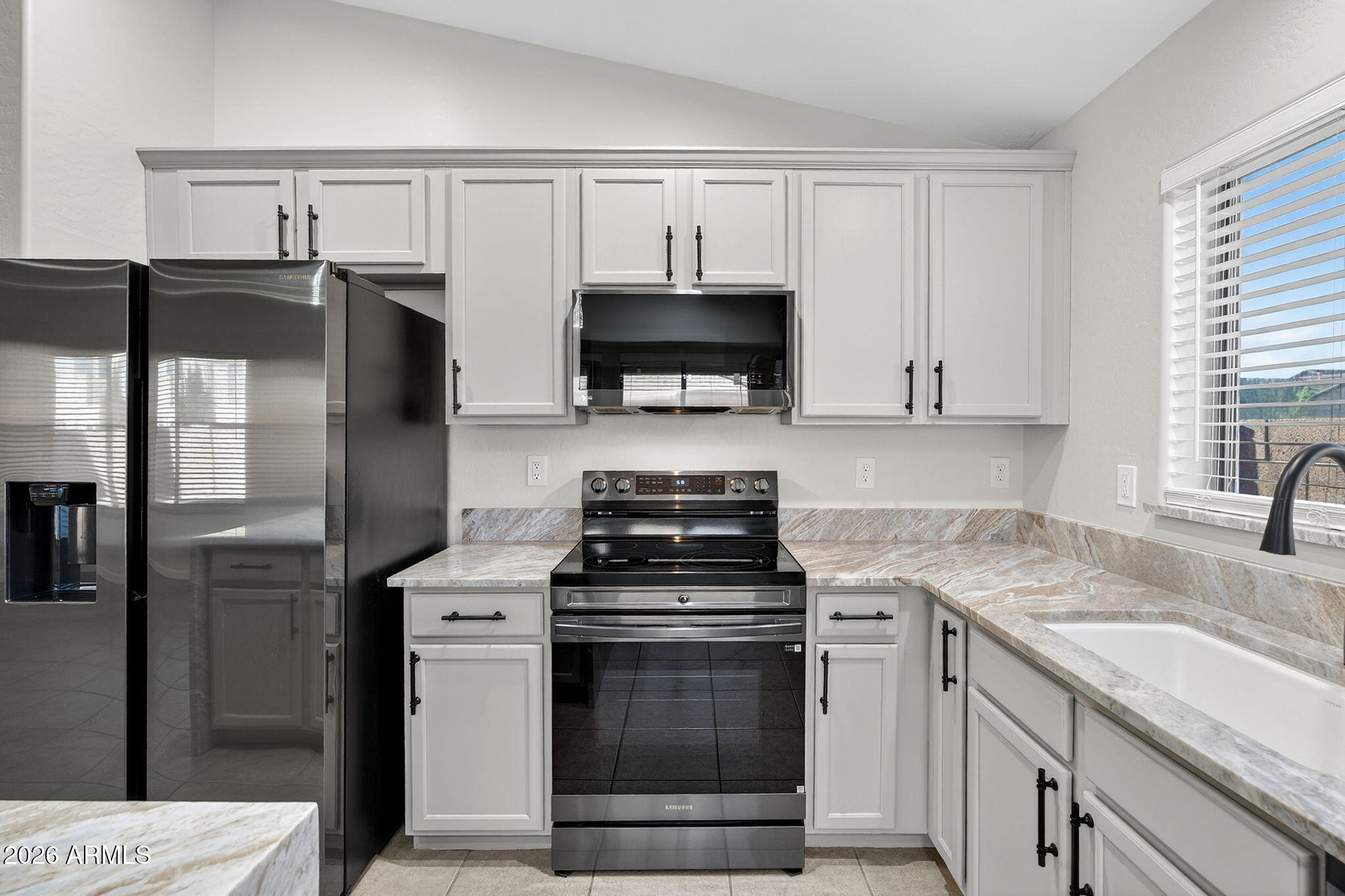 1815 South 174th Avenue Goodyear, AZ 85338 - Photo 14 of 57 a kitchen with stainless steel appliances granite countertop a stove a refrigerator and a sink