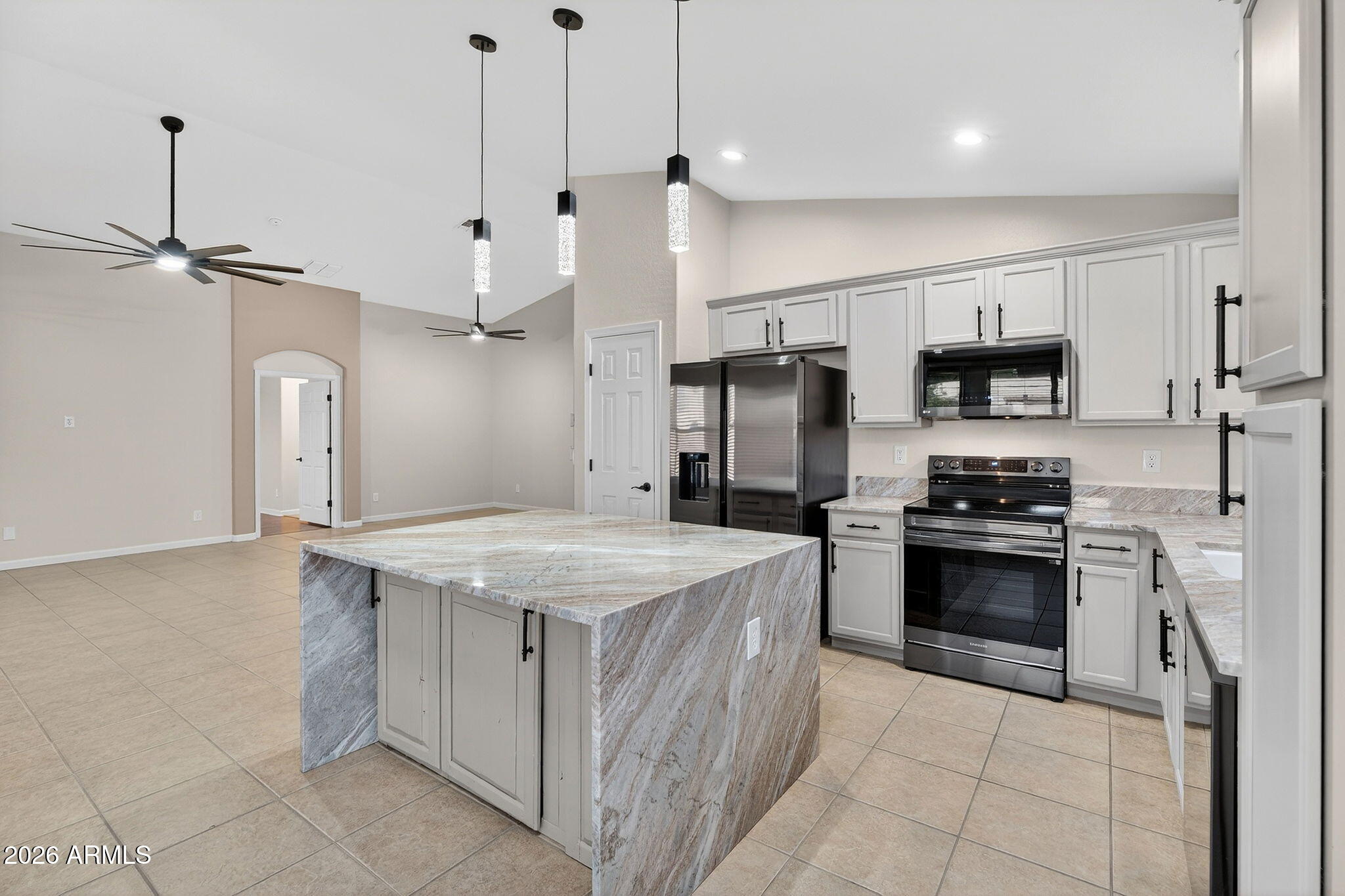 1815 South 174th Avenue Goodyear, AZ 85338 - Photo 17 of 57 a kitchen with stainless steel appliances granite countertop a sink stove and refrigerator