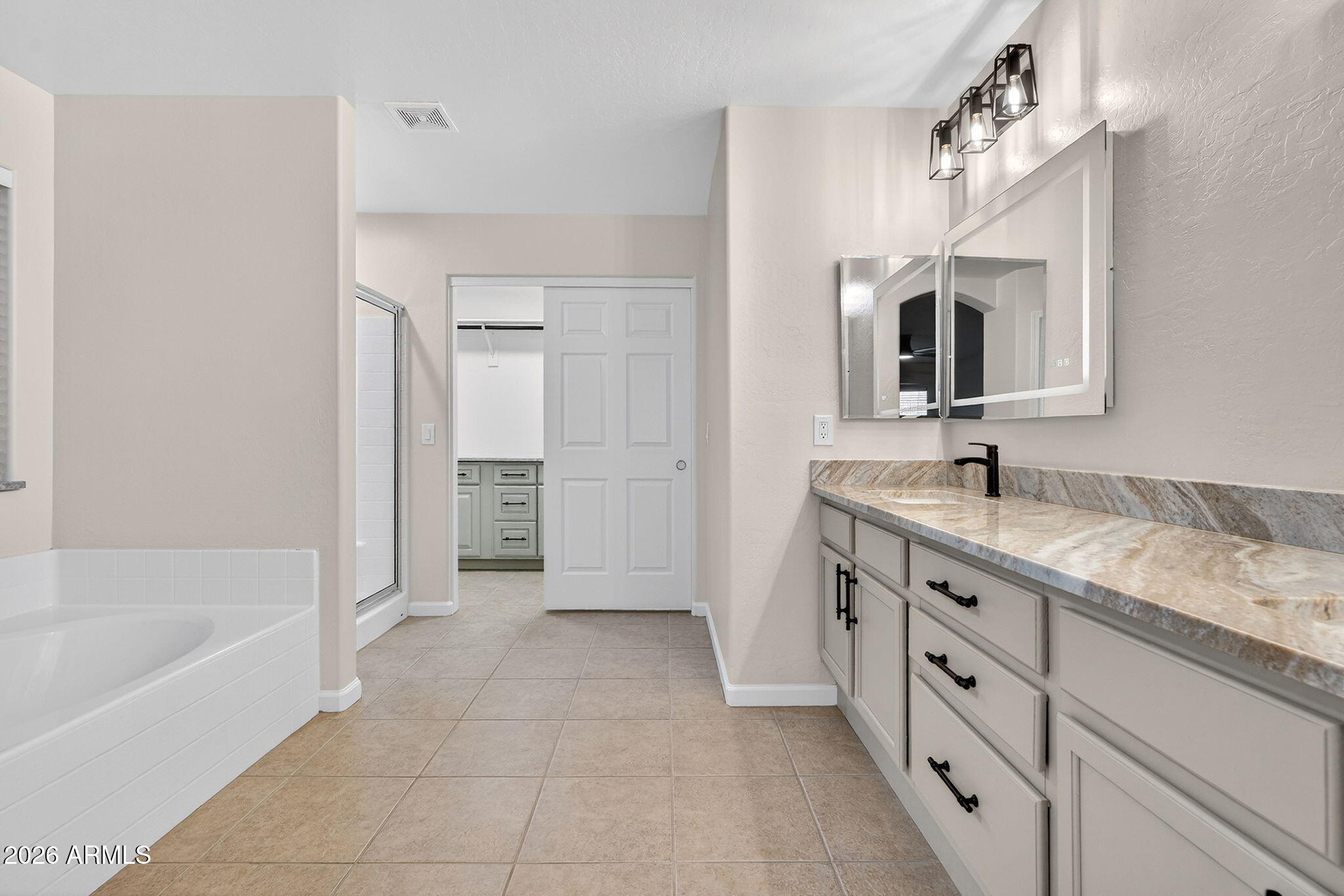 1815 South 174th Avenue Goodyear, AZ 85338 - Photo 33 of 57 a spacious bathroom with a granite countertop sink mirror and bathtub