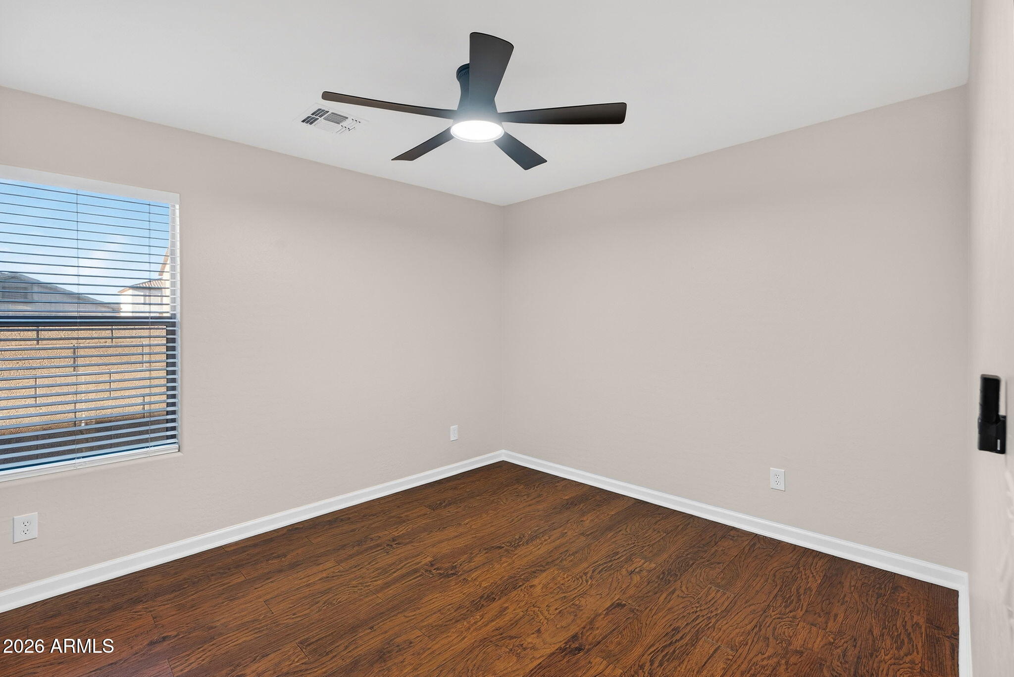 1815 South 174th Avenue Goodyear, AZ 85338 - Photo 40 of 57 a view of a room with wooden floor and a ceiling fan