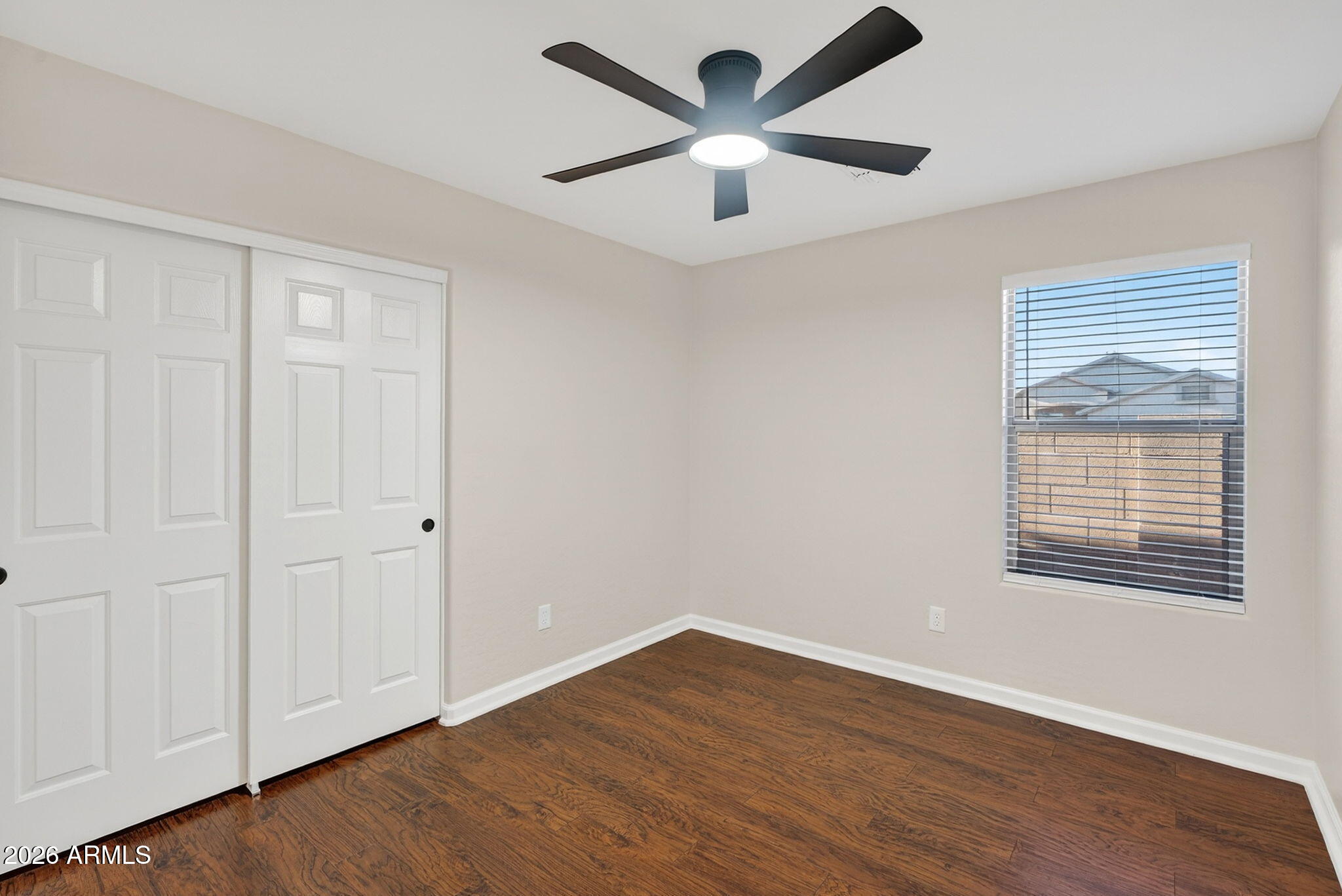 1815 South 174th Avenue Goodyear, AZ 85338 - Photo 41 of 57 an empty room with wooden floor and windows