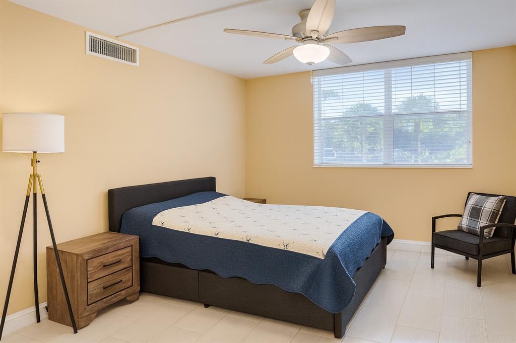 6161 Northwest 2nd Avenue, Unit 121 Boca Raton, FL 33487 - Photo 14 of 20 a bedroom with a bed and a chandelier