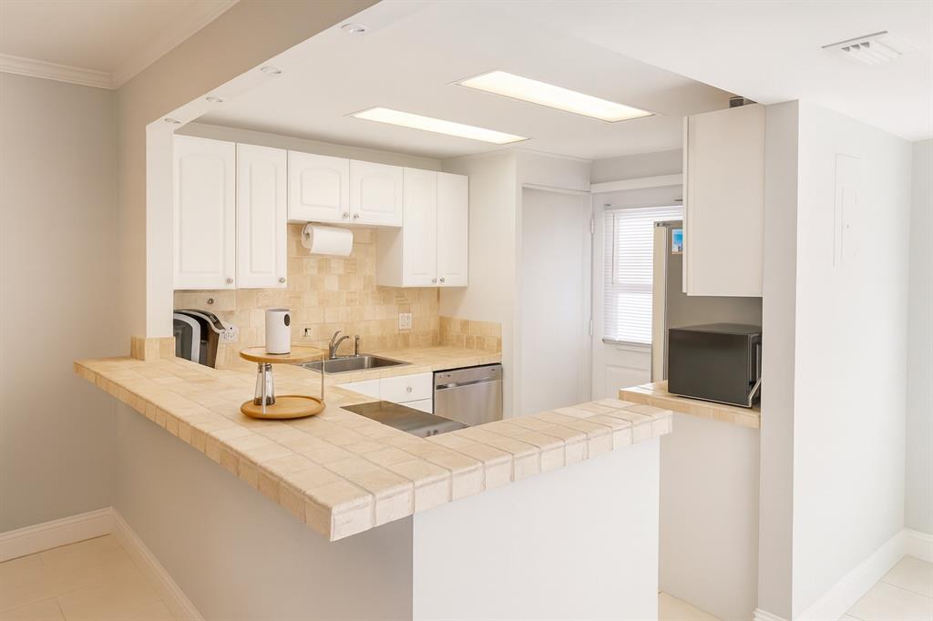 6161 Northwest 2nd Avenue, Unit 121 Boca Raton, FL 33487 - Photo 2 of 20 a kitchen with sink a stove and cabinets