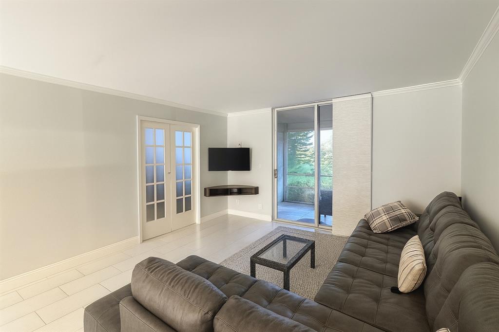 6161 Northwest 2nd Avenue, Unit 121 Boca Raton, FL 33487 - Photo 5 of 20 a living room with furniture a flat screen tv and a large window