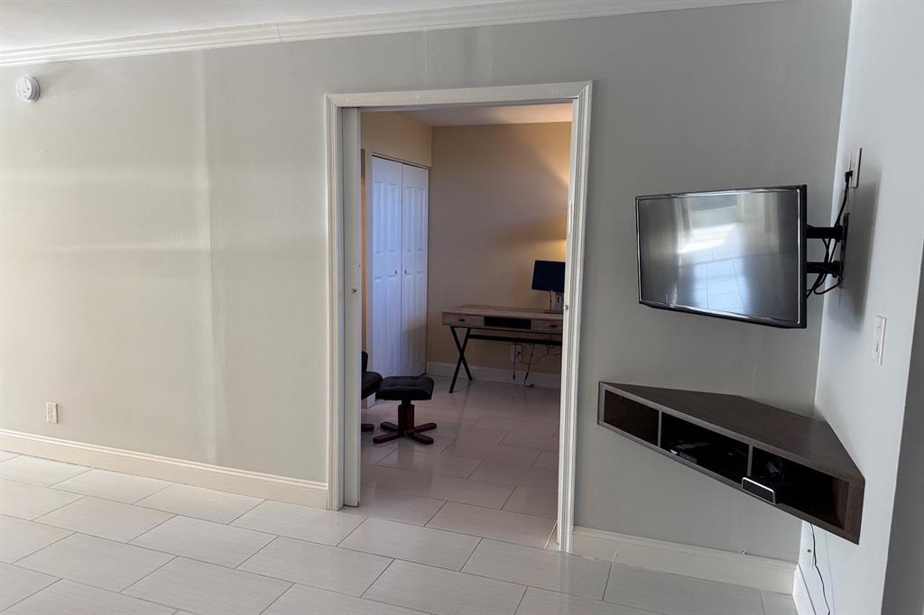 6161 Northwest 2nd Avenue, Unit 121 Boca Raton, FL 33487 - Photo 6 of 20 a view of a hallway to a livingroom with furniture and a workspace