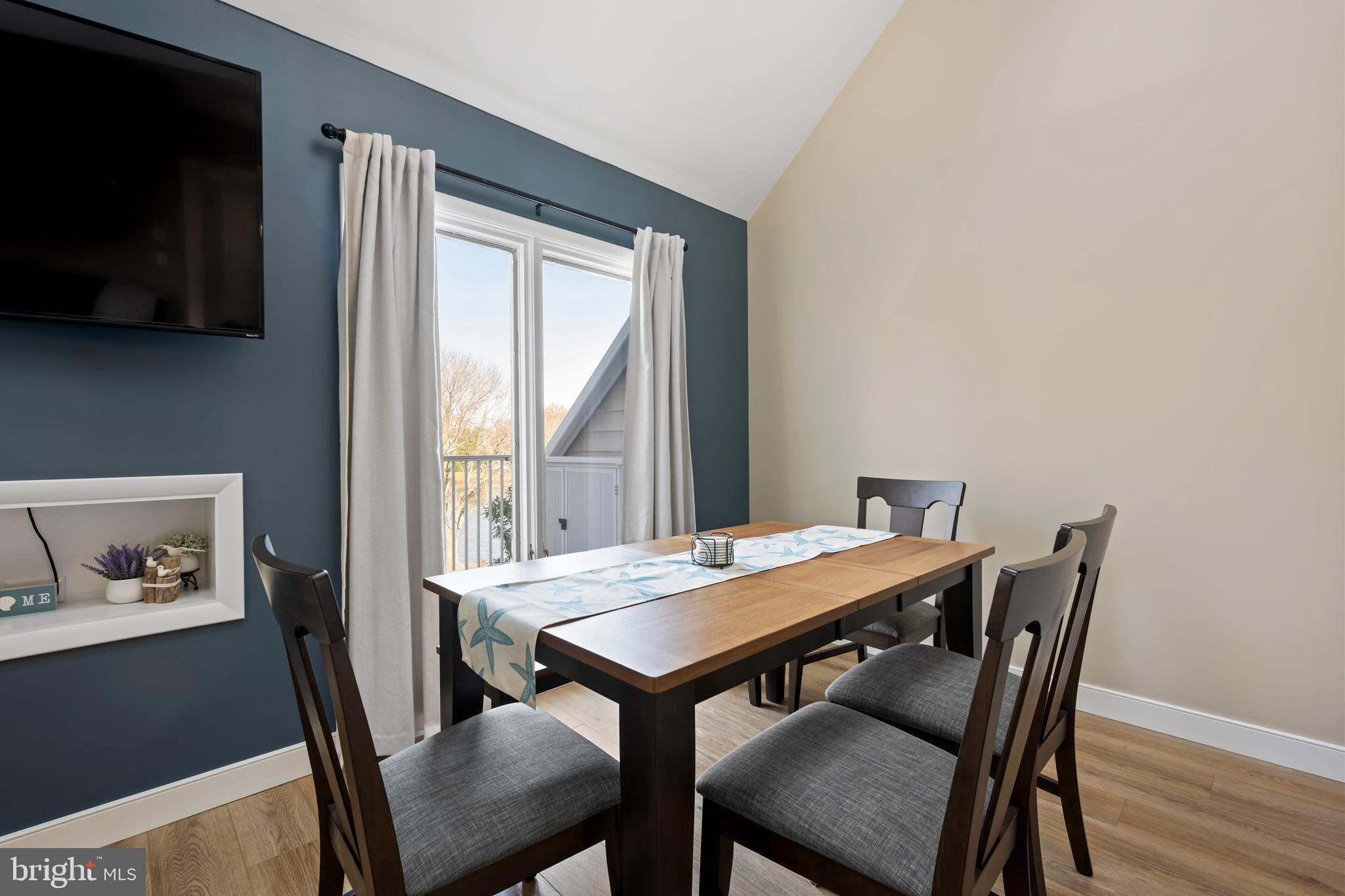 20852 Spring Lake Drive, Unit 405 Rehoboth Beach, DE 19971 - Photo 22 of 45 a view of a dining room with furniture window and wooden floor