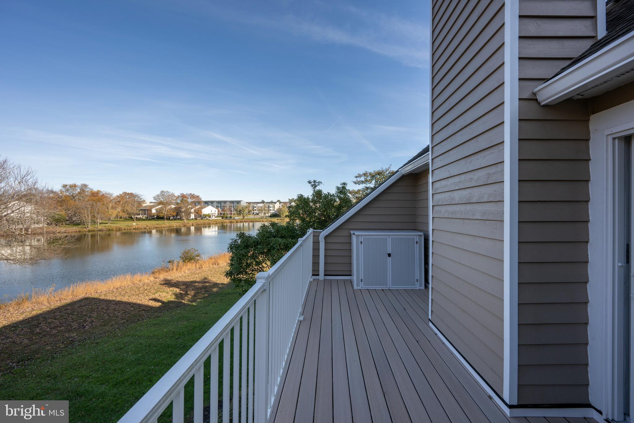 20852 Spring Lake Drive, Unit 405 Rehoboth Beach, DE 19971 - Photo 26 of 45 a balcony with wooden floor and lake view