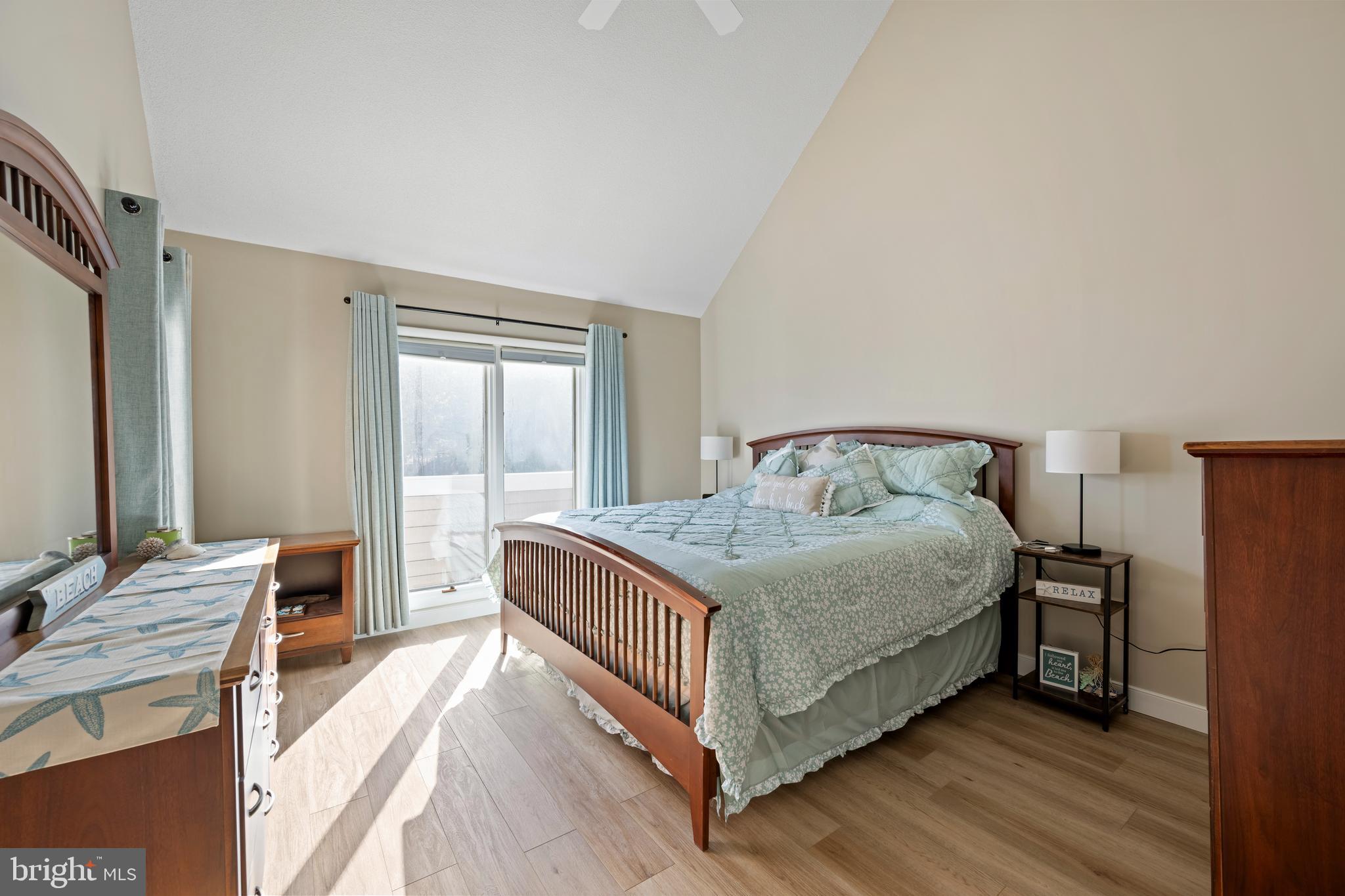 20852 Spring Lake Drive, Unit 405 Rehoboth Beach, DE 19971 - Photo 10 of 45 a bedroom with a bed and a flat tv screen on dresser