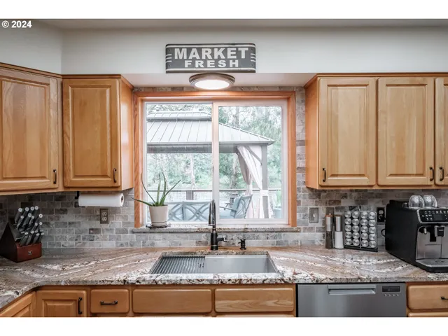 a kitchen with granite countertop a stove a sink and a counter top space