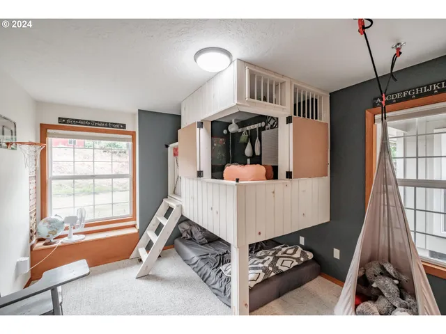 a bedroom with a bed a dresser and next to a window