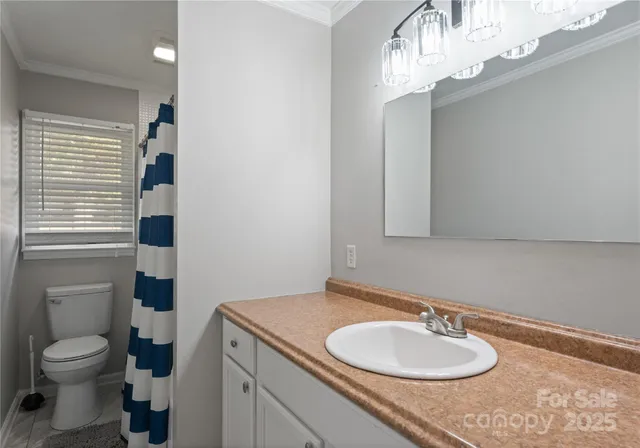 a bathroom with a granite countertop toilet a sink and a mirror