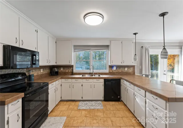 a kitchen with a sink white cabinets and appliances