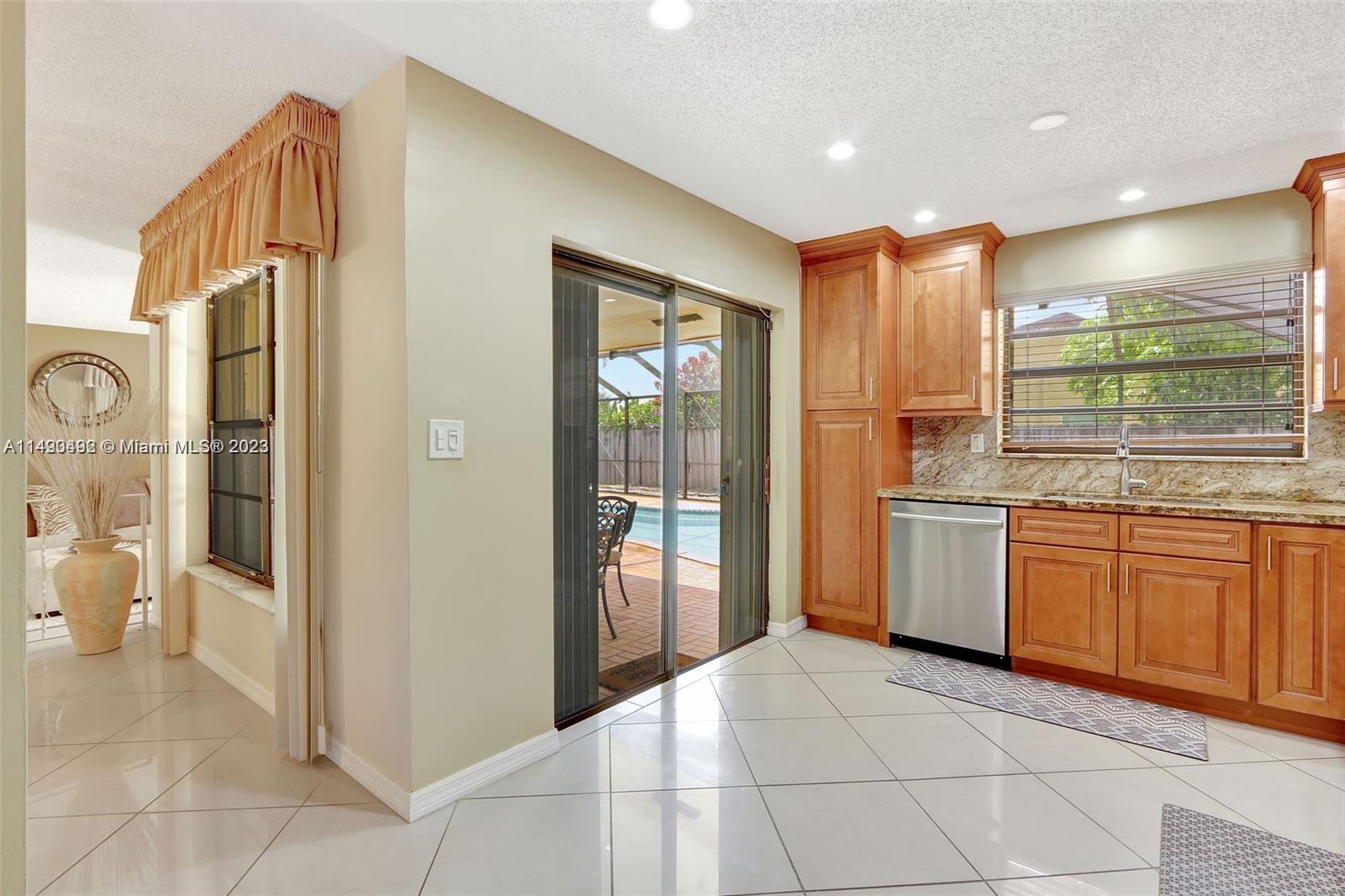 Palmetto Estates Miami, FL 33157 - Photo 10 of 26 a kitchen with granite countertop a refrigerator and white cabinets