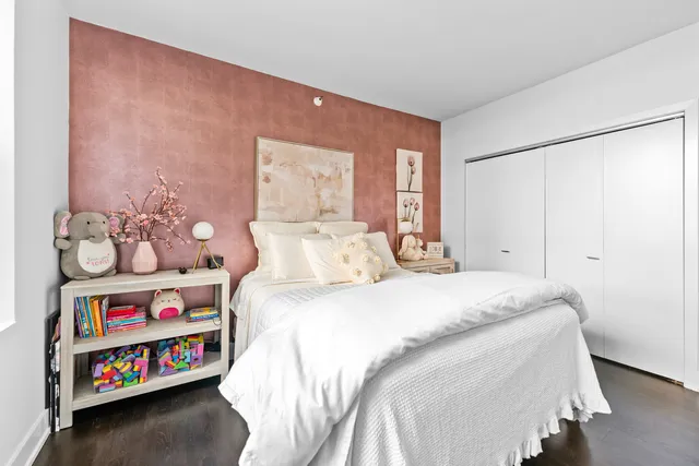 a bedroom with bed and book shelf