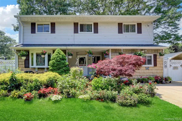 a front view of a house with a yard and outdoor seating