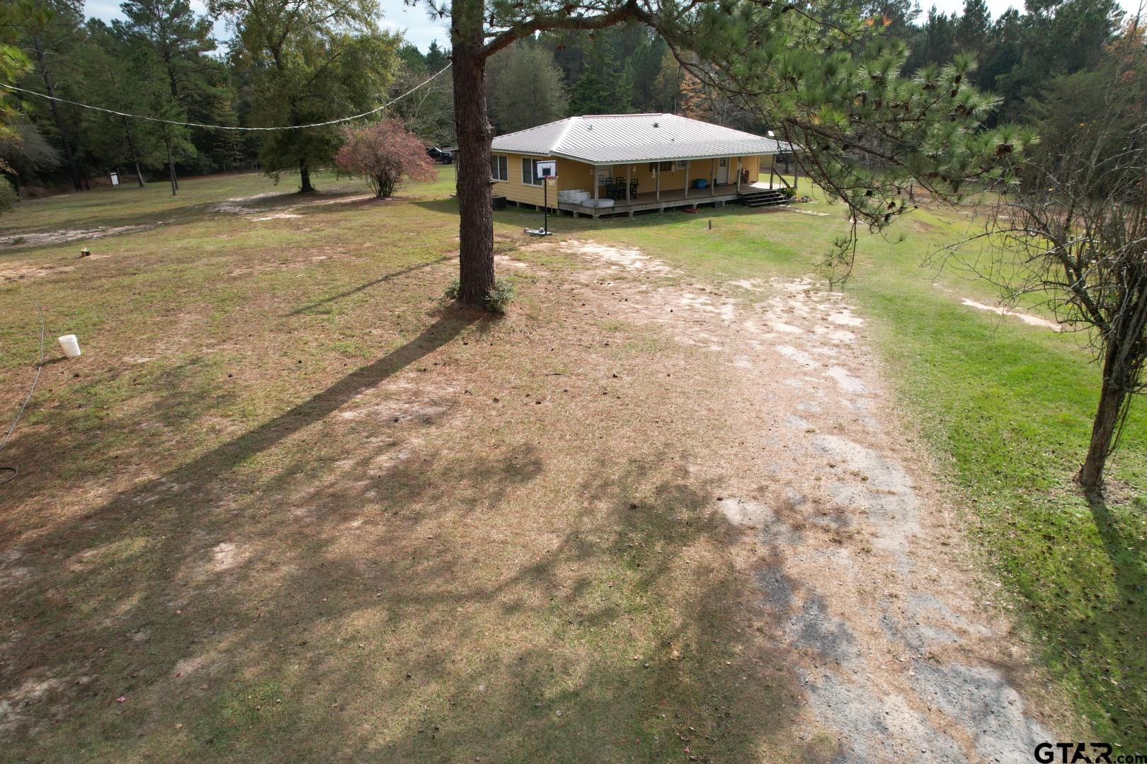 1271 County Road 3685 Joaquin, TX 75954 - Photo 2 of 46 a backyard of a house with a yard and outdoor seating