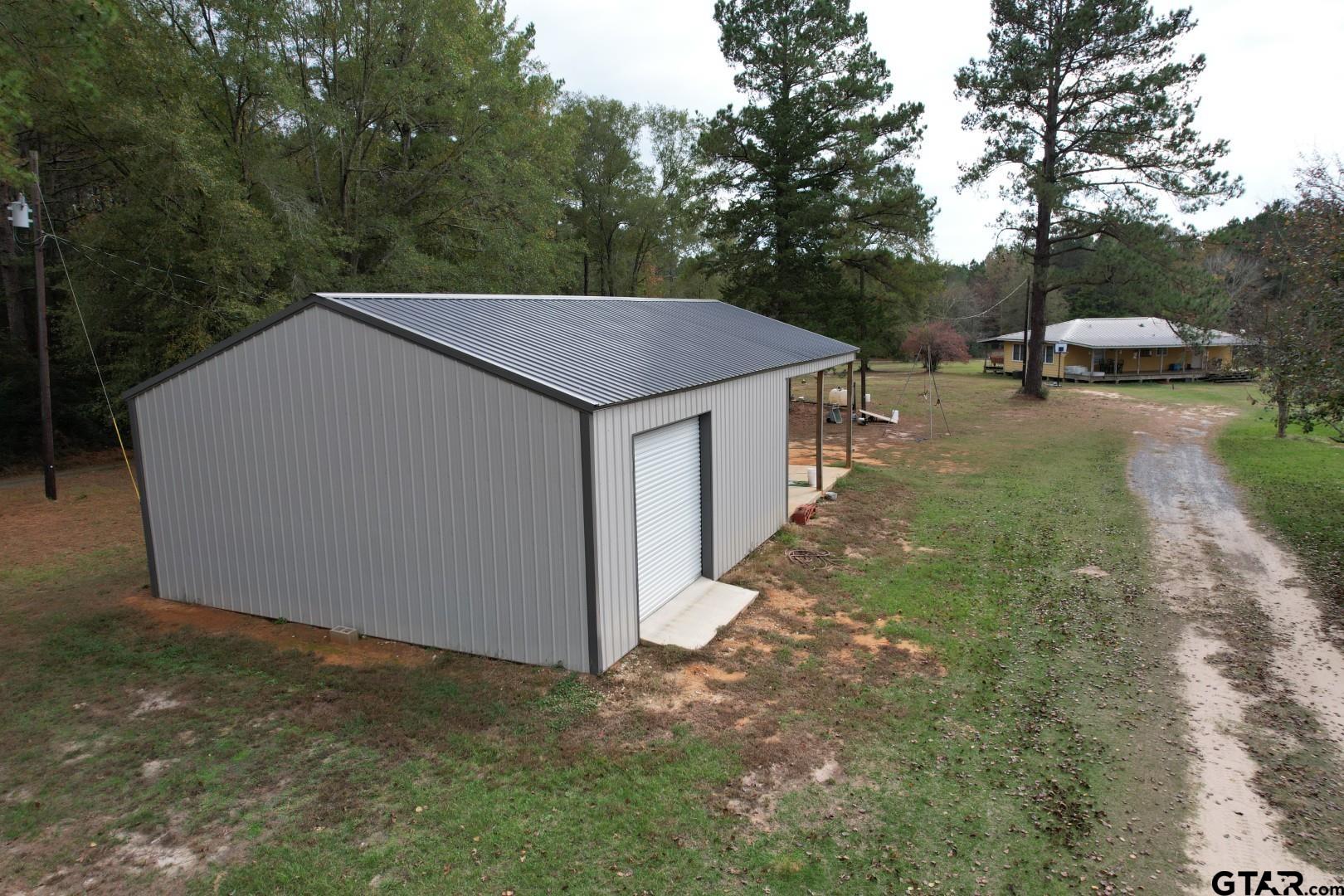1271 County Road 3685 Joaquin, TX 75954 - Photo 6 of 46 a yellow house with tall trees in front of it