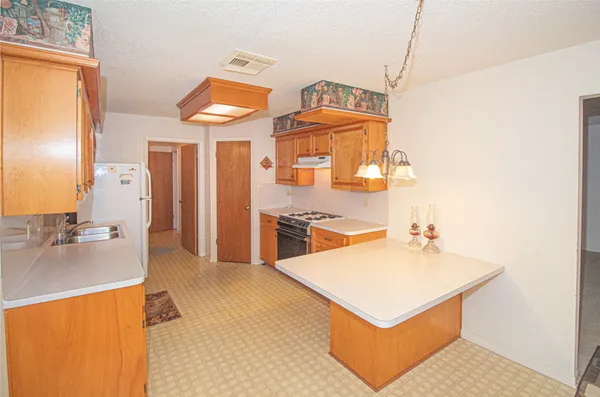 a kitchen with stainless steel appliances a stove a sink and a refrigerator