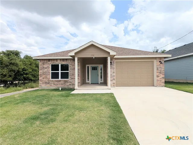a front view of a house with a garden and yard