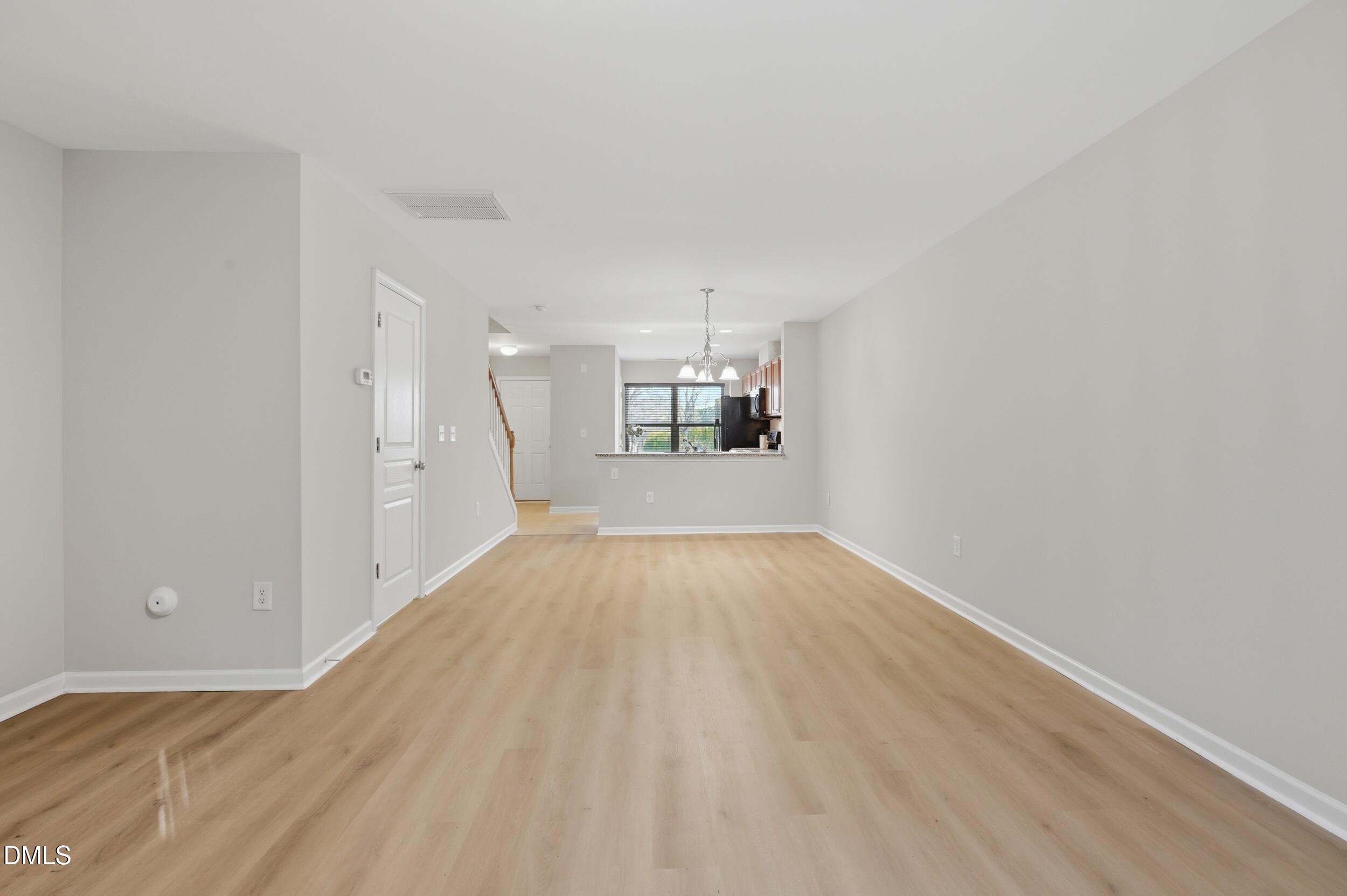2907 Berkeley Springs Place Raleigh, NC 27616 - Photo 12 of 34 wooden floor in an empty room with a window